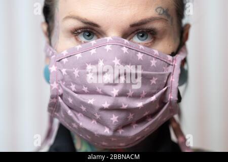 26 mars 2020, Saxe, Zwickau: Daniela Beck, tattoo artiste porte un garde-bouche auto-piqué. Beck et d'autres femmes de Zwickau ont fait des cousues de bouche en temps de pandémie de Corona. Photo: Sebastian Kahnert/dpa-Zentralbild/ZB Banque D'Images