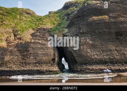 Surfeur approchant le Gap, Taitomo Rock, Tasman Lookout Track, Waitakere Ranges Regional Park, près de Piha Beach, North Island, New Zeland Banque D'Images