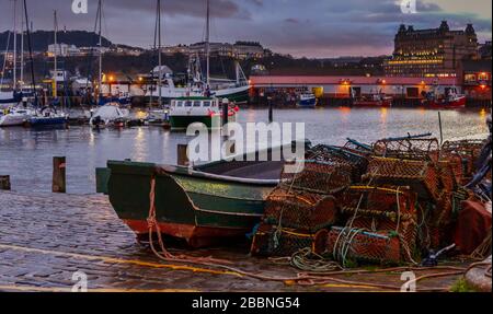 La pêche s'effectue sur des quais avec des bateaux au coucher du soleil Banque D'Images