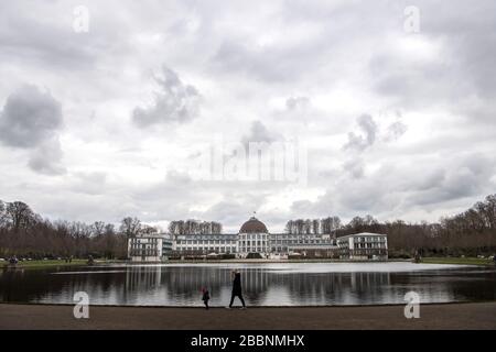 01 avril 2020, Brême: Les marcheurs passent le lac Hollersee devant le Parkhotel. Photo: Sina Schuldt/dpa Banque D'Images