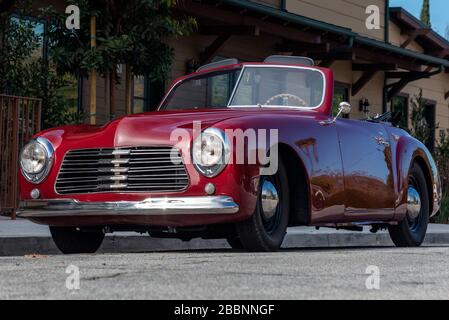 Classique 1951 Simca 8 Sport convertible voiture ressemble assez de 3/4 vue avant avec toit haut vers le bas le jour ensoleillé. Banque D'Images