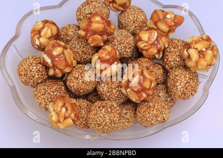 Till Gul OU Sweet Sesame Laddu et noix de pois pour le festival indien Makar Sankranti sur fond blanc Banque D'Images