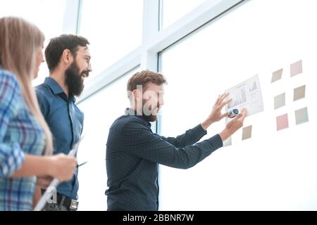 Équipe d'affaires regardant la carte financière sur une carte de verre Banque D'Images