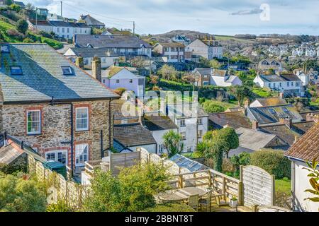 En regardant les toits du village sur la grande variété de conceptions de maison et de jardins à Polruan, Cornwall, Angleterre. Lumière du soleil sur la pierre et la propriété peinte. Banque D'Images