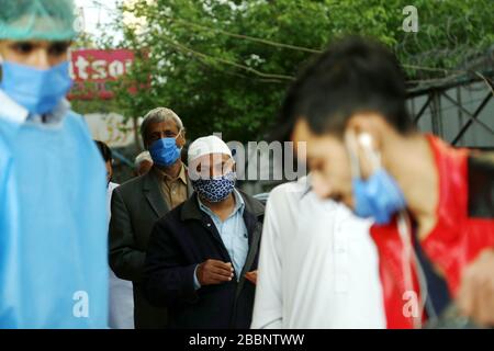 Rawalpindi, Inde. 1 avril 2020. Les gens se tiennent dans une file d'attente pour acheter des masques de visage en dehors d'une pharmacie pendant le verrouillage comme mesure préventive contre COVID-19 à Rawalpindi, dans la province du Pendjab, dans l'est du Pakistan, le 1er avril 2020. Le nombre total de cas confirmés de COVID-19 au Pakistan est passé à 2 039, avec 26 décès signalés dans tout le pays, selon les données les plus récentes publiées sur le site Web du Ministère de la santé. Crédit: Ahmad Kamal/Xinhua/Alay Live News Banque D'Images