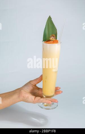 Gros plan sur la main d'une femme tenant un verre de cocktail tropical Pina colada sur fond blanc avec espace de copie. Concept de vacances d'été. Banque D'Images