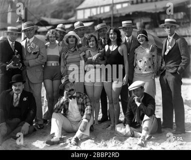 MACK SENNET COMÉDIENS VERNON DENT et BILLY BEVAN et LES BEAUTÉS DE BAIN LEOTA HIVERS CAROLE LOMBARD MARIE PERGAIN KATHRYN STANLEY et NANCY CORNELIUS pose avec les directeurs de cinéma de Seattle / Exposants sur la plage en 1928 Mack Sennet Comedies / Pathe Exchange Banque D'Images