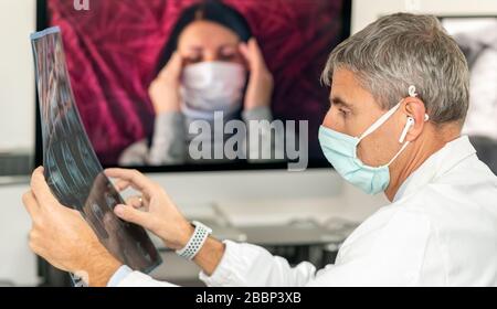 Médecin analysant les rayons X du patient avec le coronavirus avec le patient dans la vidéo sur l'écran de l'ordinateur. Banque D'Images