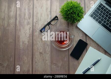 table de bureau avec ordinateur portable, smartphone et fournitures. Vue sur le dessus, plat. Banque D'Images