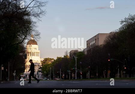 Sacramento, Californie, États-Unis. 31 mars 2020. Un marcheur solitaire traverse la 6ème rue sur le Capital Mall le soir pendant la pandémie de coronavirus le mardi 31 mars 2020 à Sacramento. Crédit: Paul Kitagaki Jr./ZUMA Wire/Alay Live News Banque D'Images