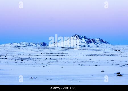 Aube rose au-dessus du paysage islandais enneigé et montagneux Banque D'Images