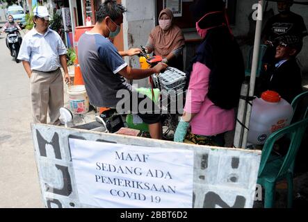 Jakarta, Indonésie. 1 avril 2020. Contrôles de serrage aux entrées résidentielles, les résidents s'enregistrent et sortent des clients en vaporisant des désinfectants et doivent se laver les mains à Pegangsaan Dua. Les résidents qui ont une aide personnelle pour resserrer l'examen à l'entrée de leur résidence vise à briser la chaîne de propagation de COVID-19, à la suite de l'augmentation des patients positifs dans la région de Jakarta. Crédit: Dasil Roszandi/ZUMA Wire/Alay Live News Banque D'Images