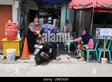 Jakarta, Indonésie. 1 avril 2020. Contrôles de serrage aux entrées résidentielles, les résidents s'enregistrent et sortent des clients en vaporisant des désinfectants et doivent se laver les mains à Pegangsaan Dua. Les résidents qui ont une aide personnelle pour resserrer l'examen à l'entrée de leur résidence vise à briser la chaîne de propagation de COVID-19, à la suite de l'augmentation des patients positifs dans la région de Jakarta. Crédit: Dasil Roszandi/ZUMA Wire/Alay Live News Banque D'Images