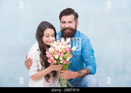 Elle vaut tous les trésors. Tulipes tendre pour fille. Bouquet de tulipes d'homme. Père donnant des tulipes fille. Père avec fleurs. Fête d'anniversaire. Journée internationale de la femme. Fleuriste. Tradition familiale. Banque D'Images