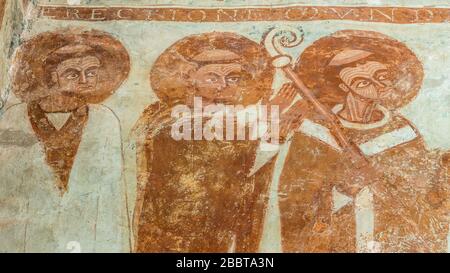 Fresque romane de 1125 de deux prêtres et un archevêque en tonsure avec son crook adorant le Christ dans l'église Finja, Suède, 9 mai 2018 Banque D'Images