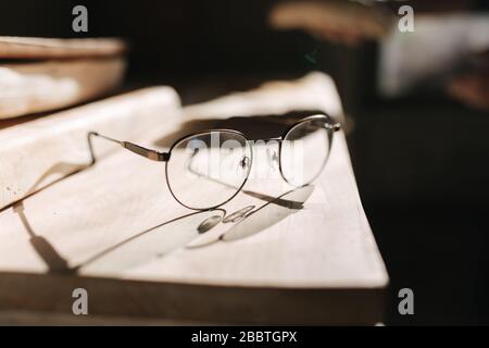 Lunettes sur la table en atelier. Coucher de soleil Banque D'Images