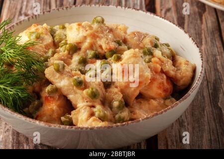 Filet de poulet braisé avec pois verts sur une table en bois Banque D'Images