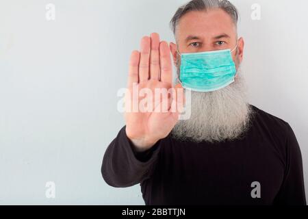 Portrait d'un homme barbu d'âge moyen dans un masque médical. Un concept du danger de coronavirus pour les personnes âgées. Banque D'Images