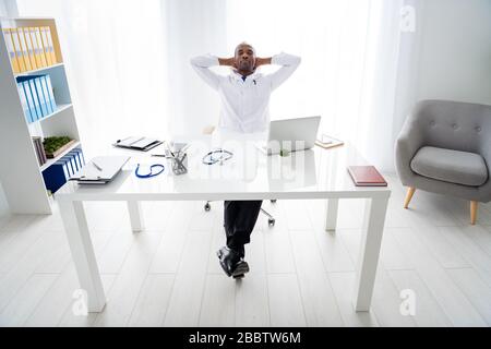 Photo pleine longueur de la famille doc sombre peau gars aider à contrôler les maladies épidémiques patients travailler la nuit besoin de repos tenir les mains derrière l'usure de la tête Banque D'Images