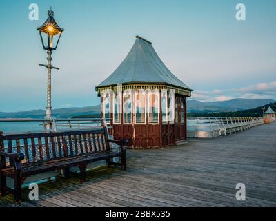 La nuit tombe à Bangor Garth Pier, une structure classée de Grade II, sur le détroit de Menai à Bangor Gwynedd North Wales UK Banque D'Images