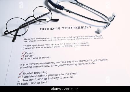 Résultat positif du test de COVID-19 ou de la nouvelle pandémie de coronavirus. Stéthoscope et nouveau résultat du test de coronavirus sur la table du médecin Banque D'Images