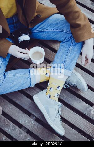 Style ville. Fille avec une tasse de café se trouve sur un parquet Banque D'Images