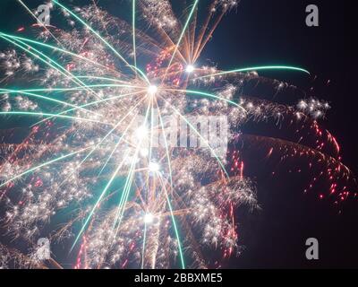 Gros plan photo de feux d'artifice avec de nombreuses branches et étincelles dans des couleurs orange turquoise et rose Banque D'Images