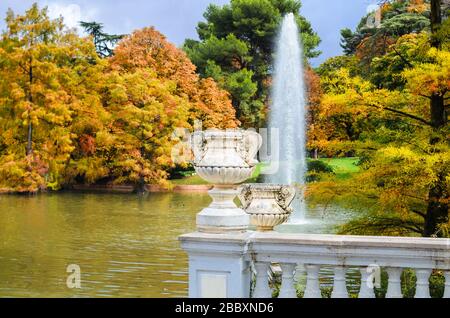 Clôture blanche avec deux vase de style ancien avec Balustre et étang avec fontaine près du Palacio de Cristal dans le parc Buen Retiro. Madrid, Espagne Banque D'Images