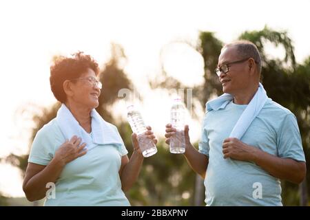 Un couple d'asian vieux homme et femme faisant de l'exercice physique extérieur et tenant une bouteille d'eau potable en plastique. Soyez sain et fort. Voiture de santé senior Banque D'Images