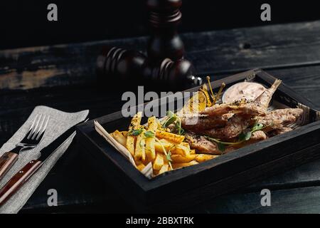 Batumi, Adjara, Géorgie. Plats de la cuisine nationale géorgienne : poisson-mulet rouge frit, citron, sauce Satsivi ou noix, compote de moules et frites. Banque D'Images