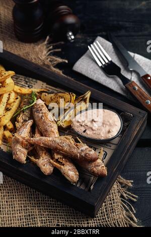 Batumi, Adjara, Géorgie. Plats de la cuisine nationale géorgienne : poisson-mulet rouge frit, citron, sauce Satsivi ou noix, compote de moules et frites. Banque D'Images