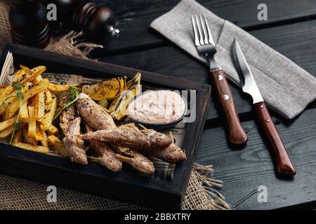 Batumi, Adjara, Géorgie. Plats de la cuisine nationale géorgienne : poisson-mulet rouge frit, citron, sauce Satsivi ou noix, compote de moules et frites. Banque D'Images