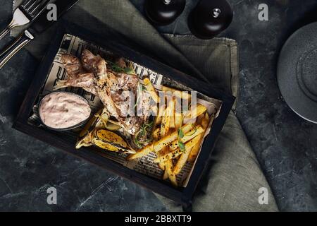 Batumi, Adjara, Géorgie. Plats de la cuisine nationale géorgienne : poisson-mulet rouge frit, citron, sauce Satsivi ou noix, compote de moules et frites. Banque D'Images