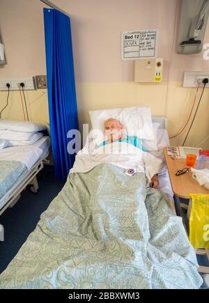 ANDOVER,HAMPSHIRE/ROYAUME-UNI- 25 DÉCEMBRE 2019:un homme âgé avec des lésions cérébrales, un parent du photographe, se trouve dans le lit de la guerre de Kingfisher Rehab Banque D'Images