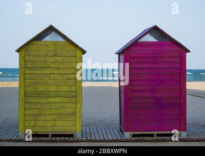 Des cabanes de plage jaunes et rouges avec la mer et le ciel clair en arrière-plan. Banque D'Images