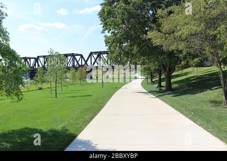 Sentier de randonnée du parc de Gênes, bâtiment du court du district, rues de Columbus, pont de la route ferroviaire encadrant des arbres verts une journée ensoleillée de printemps Banque D'Images