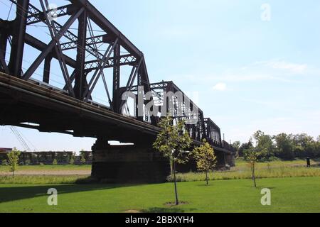 Sentier de randonnée du parc de Gênes, bâtiment du court du district, rues de Columbus, pont de la route ferroviaire encadrant des arbres verts une journée ensoleillée de printemps Banque D'Images
