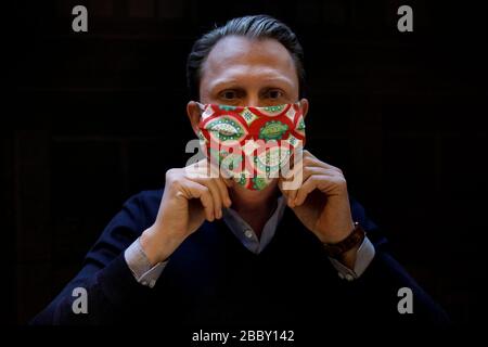 Berlin, Allemagne. 27 mars 2020. Jan Scheper-Stuke, directeur général du fabricant de cravate de Berlin Auerbach, montre un masque coloré à nez de bouche en tissu dans l'atelier de cravate. Depuis la semaine dernière, divers modèles de masques buccaux fabriqués à partir de tissus différents ont été offerts par le fabricant de cravates. Crédit: Carsten Koall/dpa/Alay Live News Banque D'Images