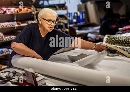 Berlin, Allemagne. 27 mars 2020. Dagmar E. Hartmann, tailleur, prépare des tissus pour la transformation en masques de bouche-nez chez Auerbach, fabricant de cravate à Berlin. Depuis la semaine dernière, divers modèles de masques buccaux fabriqués à partir de tissus différents ont été offerts par le fabricant de cravates. (À 'protection de la bouche au lieu de cravates en soie: Fabrication change de production') crédit: Carsten Koall/dpa/Alay Live News Banque D'Images