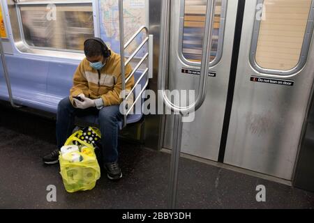 New York, États-Unis. 31 mars 2020. Un homme portant un masque facial est vu assis sur le métro de New York avec un sac d'épicerie plein de papier toilette au milieu de l'épidémie de coronavirus.l'état de New York s'est transformé en épicentre du coronavirus COVID-19 aux États-Unis avec plus de 75 000 cas confirmés et 1 500 morts signalé. Crédit: SOPA Images Limited/Alay Live News Banque D'Images