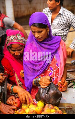 Femme de la région d'acheter des pommes au marché de rue à Fatehpur Sikri, Uttar Pradesh, Inde. La ville a été fondée en 1569 par l'empereur moghol Akbar, et Banque D'Images