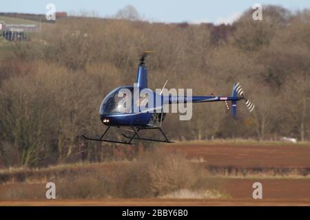 G-BTDI, un hélicoptère privé Robinson version bêta, à l'aéroport de Prestwick à Ayrshire, en Écosse. Banque D'Images