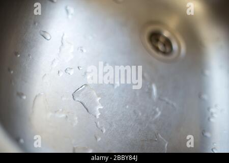 gouttes d'eau dans un lavabo métallique gros plan. Évier après le nettoyage du sewerю Banque D'Images