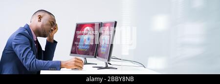 Inquiets Businessman Looking At Laptop avec Ransomware mots à l'écran sur le lieu de travail Banque D'Images