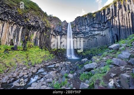 Cascade de Svartifoss entourée de colonnes de basalte de lave sombre, Islande Banque D'Images