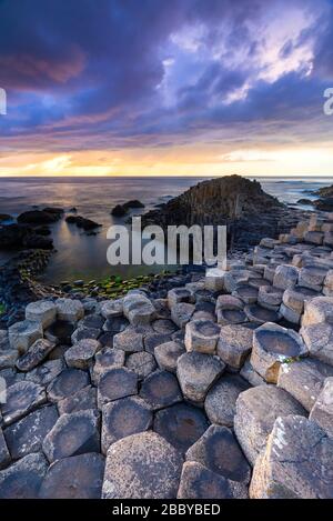 Un coucher de soleil épique sur la chaussée des Géants avec ses colonnes de basalte emblématiques. Comté d'Antrim, région d'Ulster, Irlande du Nord, Royaume-Uni. Banque D'Images