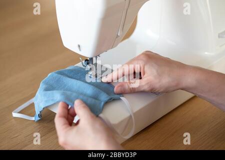 processus de travail, masques à coudre pour la protection, femme mains masques à coudre sur la machine à coudre en raison du manque de matériel pendant la crise du covid-19 Banque D'Images