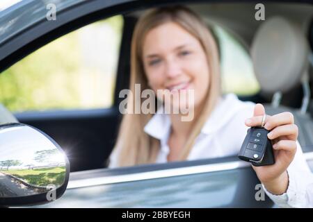 La jeune femme montre fièrement les clés de sa première voiture Banque D'Images