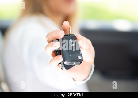 La jeune femme montre fièrement les clés de sa première voiture Banque D'Images