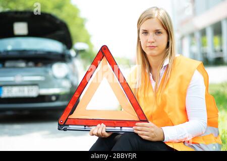 Une jeune femme se casse avec sa voiture Banque D'Images